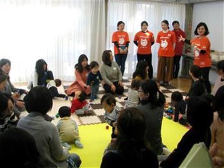 「地域交流会」でオレンジのシャツを着た「ママサポーター」と交流する親子たち＝横浜市都筑区